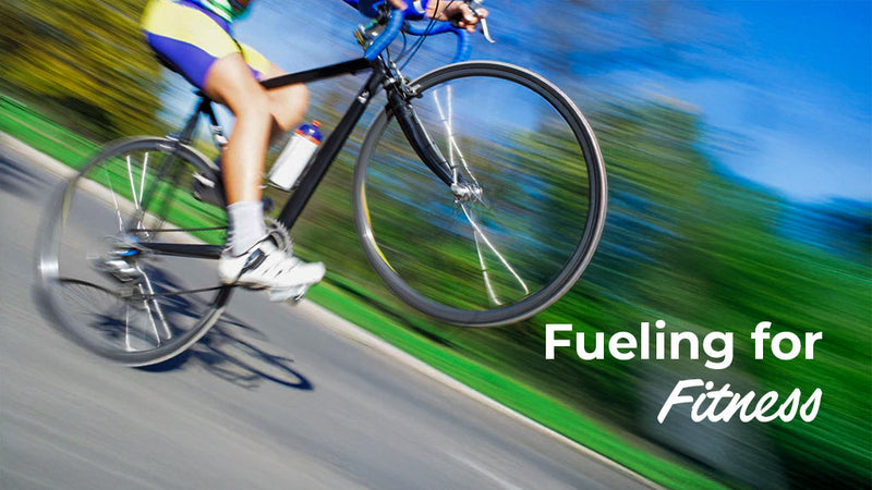 A high-motion action shot of a cyclist riding quickly past green trees, featuring the text "Fueling for Fitness" to highlight the importance of nutrition and hydration for active lifestyles.