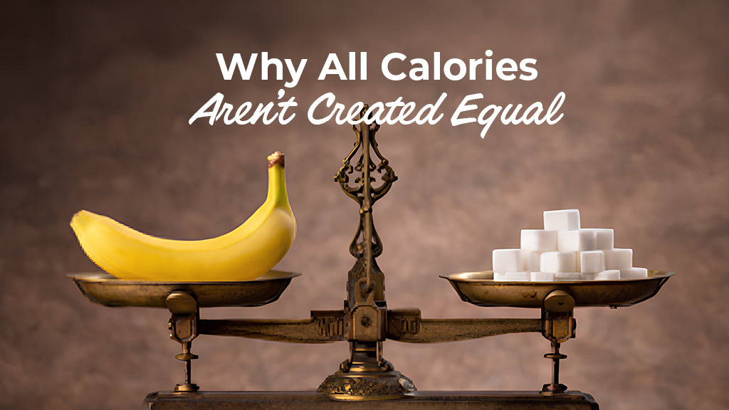 An image titled "Why All Calories aren't created equal." A metal scale balances whole foods like a coconut and bananas on the left against a cheeseburger, energy drinks, and sugar cubes on the right. The scale tips heavily toward the processed foods.